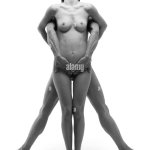 Nude man standing behind nude woman mans hands over womans groin womans head back bw Stock Photo