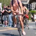 World Naked Bike Ride London UK. Naked cyclist taking part in the cycling event. Male nude rider with mobile phone covering genitalia Stock Photo