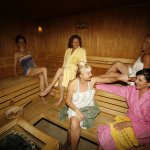 Naked mature ladies relaxing together in a sauna