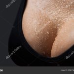 Sexy boob. Close up of breast of girl presenting her bra. Woman with big natural sexy