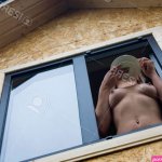A Naked-chested Girl Holds A Plate In Her Hand And Looks Out Of The Window. View From Below. Stock Photo Picture and Royalty Free Image. Image 136551402.